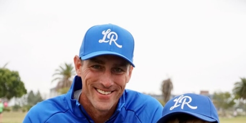 Man beside a little kid holding baseball cards