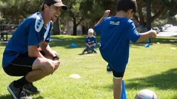 coach with a kid playing soccer